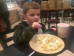 Jason eating pasta in his jacket 