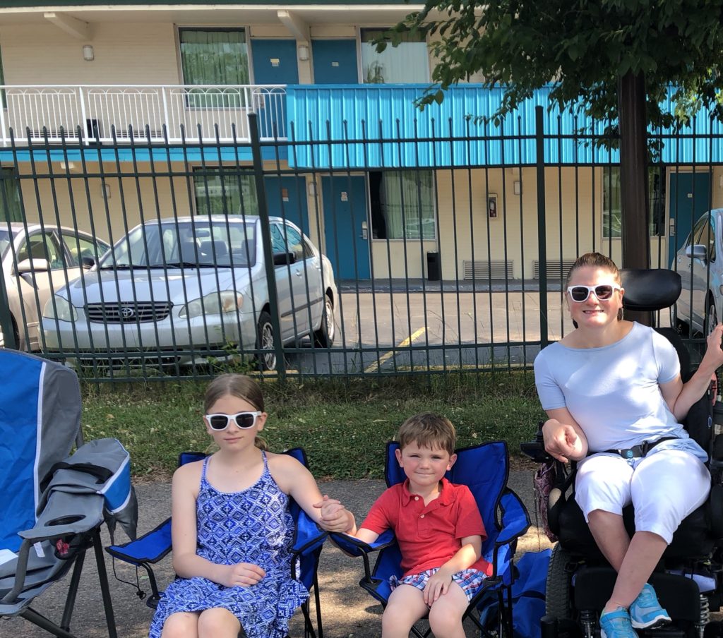 Mom and kids sitting waiting for a parade