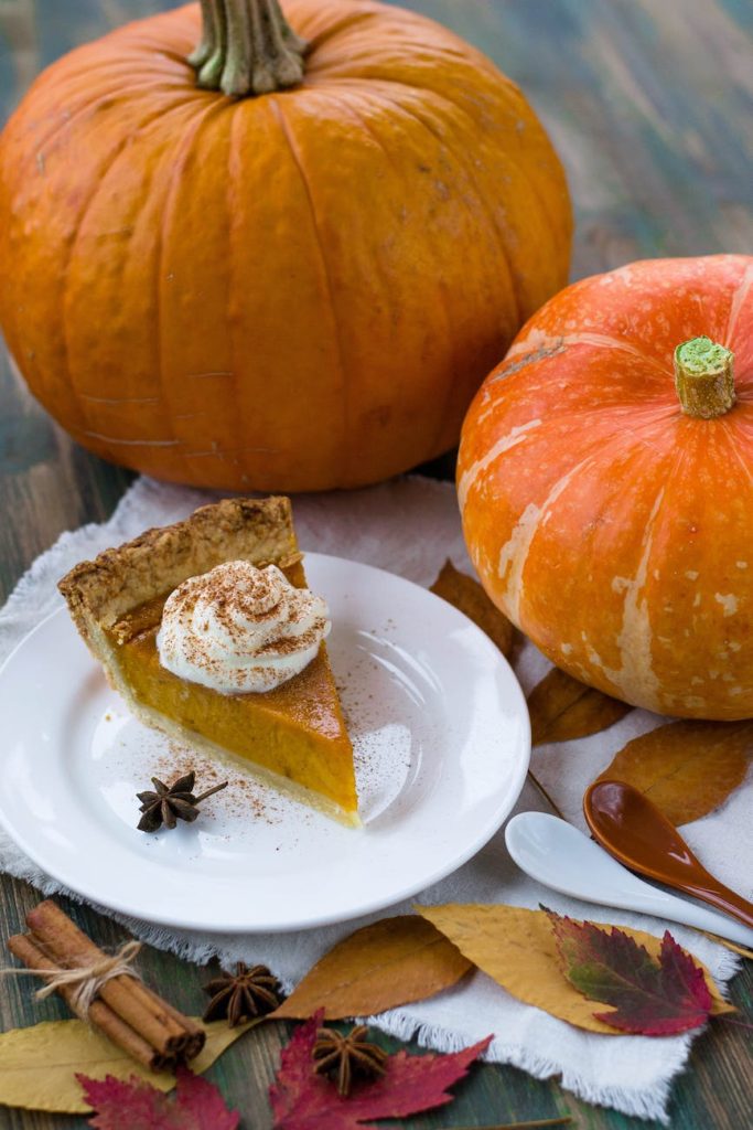 delectable sliced pumpkin pie on white ceramic plate