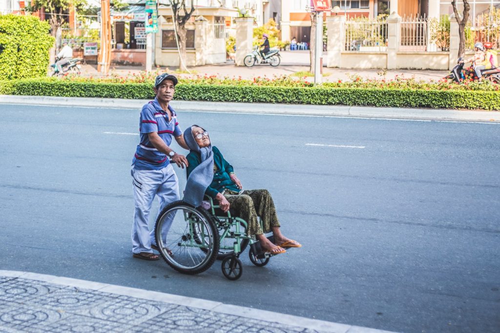 man pushing a woman sitting on wheelchair